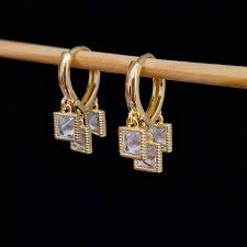 Trendy gold earring with white stone